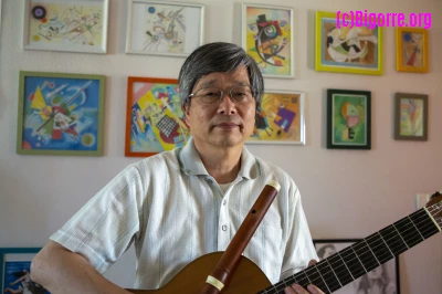 Takashi Ogawa, guitare et traverso en main devant une partie de ses dessins/ Stéphane Boularand (c)Bigorre.org