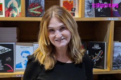 Marie-Pierre Vieu devant une bibliothèque pleine de livres édités par Arcane 17/ Stéphane Boularand (c)Bigorre.org