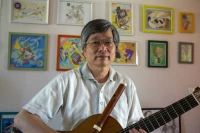 Takashi Ogawa, guitare et traverso en main devant une partie de ses dessins/ Stéphane Boularand (c)Bigorre.org