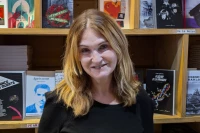 Marie-Pierre Vieu devant une bibliothèque pleine de livres édités par Arcane 17/ Stéphane Boularand (c)Bigorre.org